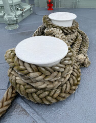 Fototapeta premium Rope on a ship. Detail of a nautical rope. Boat rope wrapped around anchors for mooring. Looped rope in a port.