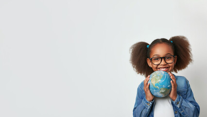 African american girl holding globe in hands. Smiling black child in glasses holding planet Earth....