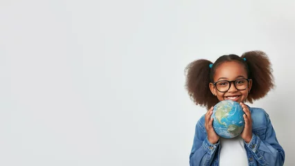 Foto op Canvas African american girl holding globe in hands. Smiling black child in glasses holding planet Earth. School girl isolated on white background with copy space. Black History Month, Peace Day, Earth Day © Milan