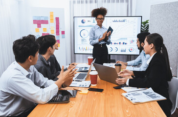 Young african businesswoman presenting data analysis dashboard on TV screen in modern meeting. Business presentation with group of business people in conference room. Concord