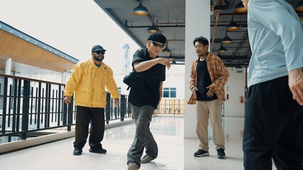 Hipster perform break dancing while partner dancing together at corridor, modern mall. Hip-hop...