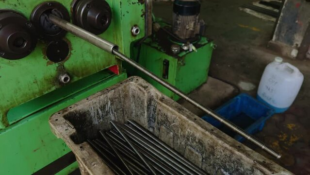 Industrial lathe machine in a workshop with metal bar clamped for machining
