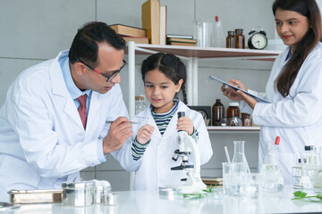 Asian scientist kid student and Indian teacher with plant at biology class in school laboratory,...
