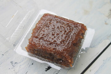 Indonesian food called wajik made of sticky rice and brown sugar in mica plastic on the table