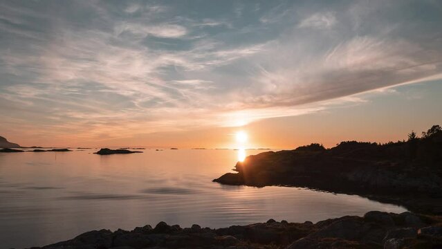 A timelapse of the midnight sun moving over horizon above the Norwegian fjord.
