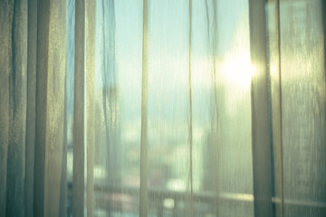 sheer curtain (translucent fabric) and balcony from high rise condominium with sunlight reflection,...