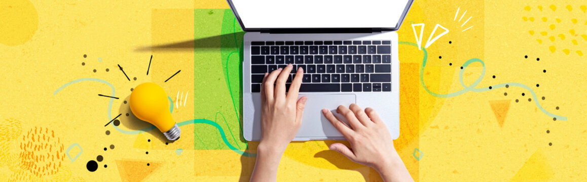Person using a laptop computer and a light bulb - Flat lay