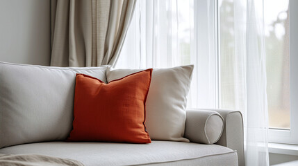 Close up of fabric sofa with terra cotta pillow against window and white wall. Scandinavian home interior design of modern living room