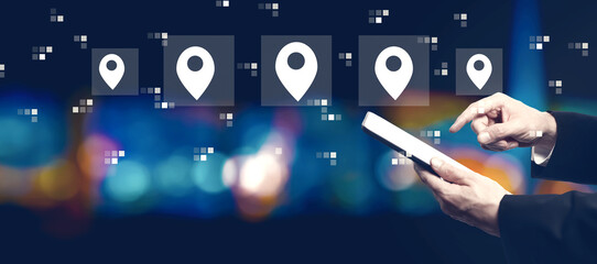 Map pin concept with businessman using a tablet computer at night