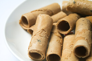 Crispy egg roll or crispy golden curl placed in a white plate, white background. Isolated.