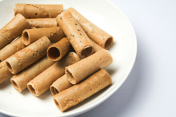 Crispy egg roll or crispy golden curl placed in a white plate, white background. Isolated.