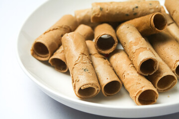 Crispy egg roll or crispy golden curl placed in a white plate, white background. Isolated.