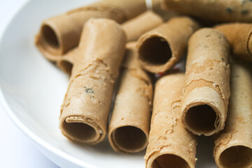 Crispy egg roll or crispy golden curl placed in a white plate, white background. Isolated.