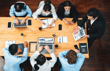 Panorama top view diverse group of business analyst team analyzing financial data report paper on meeting table. Chart and graph dashboard by business intelligence analysis. Meticulous
