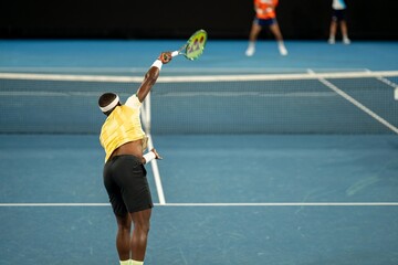 Professional athlete playing tennis on a sports court in europe.