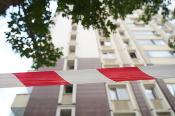 Fencing tape in front of a high-rise apartment building.