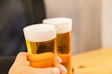 おいしそうなグラスビールで乾杯する人