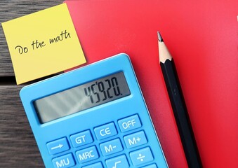 Calculator and pencil writing on paper note DO THE MATH - to examine the facts and figures to reach...