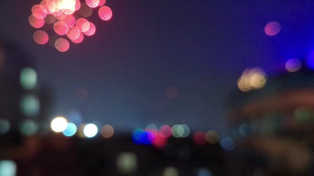 blur city background at night with fireworks on sky