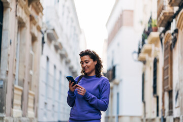 Woman browsing smartphone on street