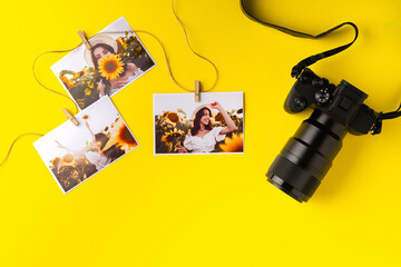 Photo camera with colorful printer photos on yellow background