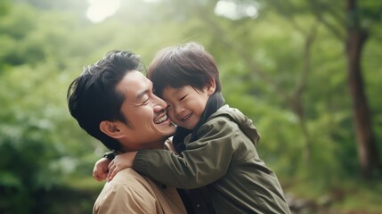 Fototapeta premium Father, bonding kiss and boy child hug happy in nature with quality time together outdoor. Happiness, laughing and family love of a dad and kid in a park enjoying nature hugging with care and a smile.