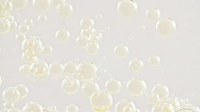 Gold Clear Bubbles Form and Float to Another Ones on Transparent Surface on White Background. The Medicine Concept, Health Care, Body Care Cosmetics. Macro Shot. Slow Motion. High quality FullHD