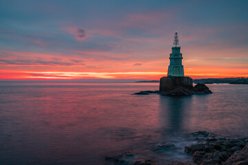 Solitude Radiance: Lone Lighthouse at Sunrise