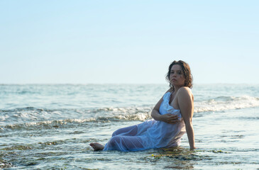Fototapeta na wymiar Beautiful bride sitting on ocean shores