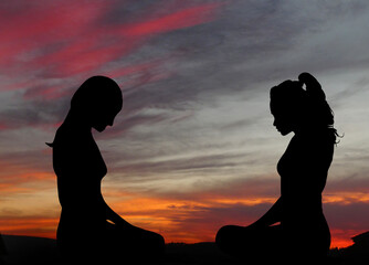 Silhouetten Körper sitzende Frauen - Meditation und Ruhe im Schneidersitz vor dem Abendhimmel