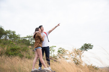 Romantic couples enjoy and explore the forest or woods and bond with love and romance. Young Asian tourists enjoying tourism in green nature park forests. Outdoor leisure activity people.