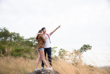 Fototapeta premium Romantic couples enjoy and explore the forest or woods and bond with love and romance. Young Asian tourists enjoying tourism in green nature park forests. Outdoor leisure activity people.