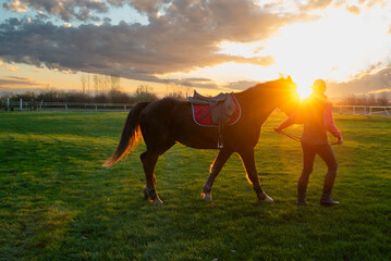Woman and her horse on a sunset