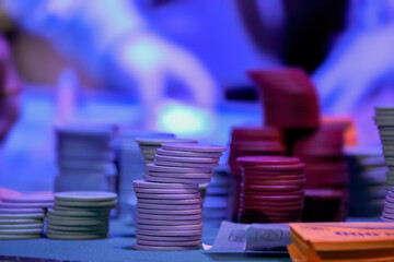 A Several stacks of gambling chips sitting on the betting mat for an up-close view on the dark.