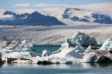Iceland-iceberg in Jokulsarlon glacier lagoon with Vatnajökull National Park in the background - obrazy, fototapety, plakaty