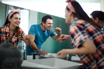 Happy Young brunette Couple Brushing Teeth In Bathroom, Loving Man and His Wife