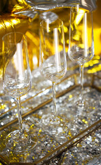 Close up of shiny glasses of champagne over golden and silver balloons background