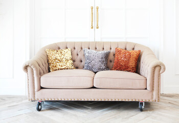 One classic sofa with pillows against a white wall and floor
