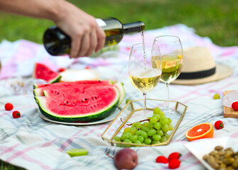Picnic with white wine on green grass