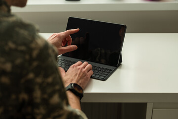 Caucasian soldier in army uniform in front of computer feeling happy and excited. American soldier...