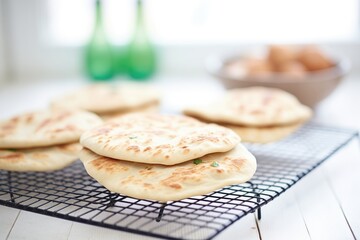 freshly baked pita loaves on a cooling wire rack