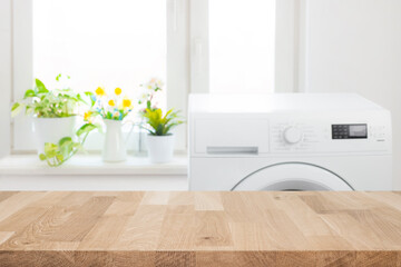 Empty wooden table on blurred background of washing machine and window in laundry room - obrazy, fototapety, plakaty