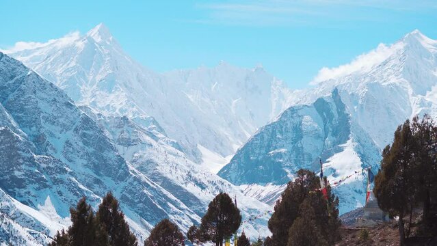 4K Landscape shot of snow covered Himalayan mountain peaks during the winter season as seen from Keylong at Lahaul Valley in Himachal Pradesh, India. Snowy mountain peaks during the winter season.