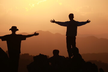 silhouette of two people on sunset background