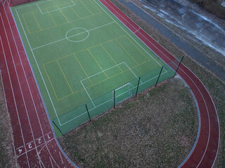 sports stadium with a running track with several lanes. inside oval there is a small football field...