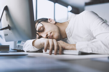 Lazy office worker sleeping at his desk - obrazy, fototapety, plakaty