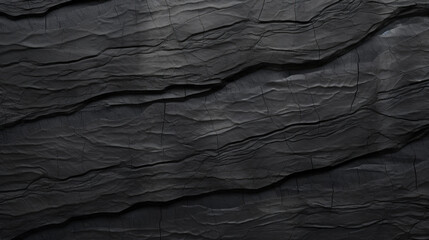 High-resolution image of the dark, textured surface of black slate rock with natural lines and grooves.