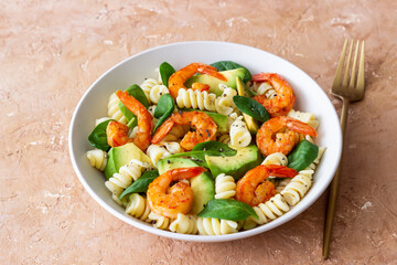 Pasta salad with shrimps, avocado and spinach. Healthy eating. Seafood.