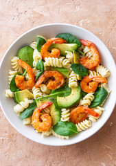 Pasta salad with shrimps, avocado and spinach. Healthy eating. Seafood.
