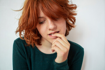 girl with red hair plays with emotions using her hands and facial expressions